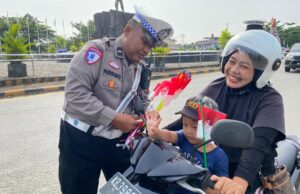 Polres Melawi Bagikan Bendera Kepada Masyarakat Pengguna Jalan