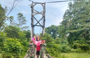 Babinsa Kodim 1204/Sanggau atasi kesulitan rakyat menyeberangi jembatan.